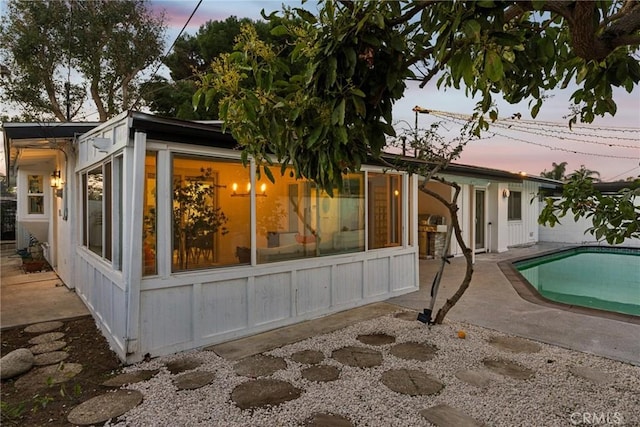 property exterior at dusk with a patio