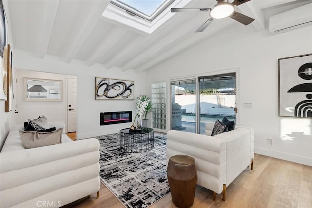 living room with lofted ceiling with skylight, a wall mounted air conditioner, ceiling fan, and light wood-type flooring