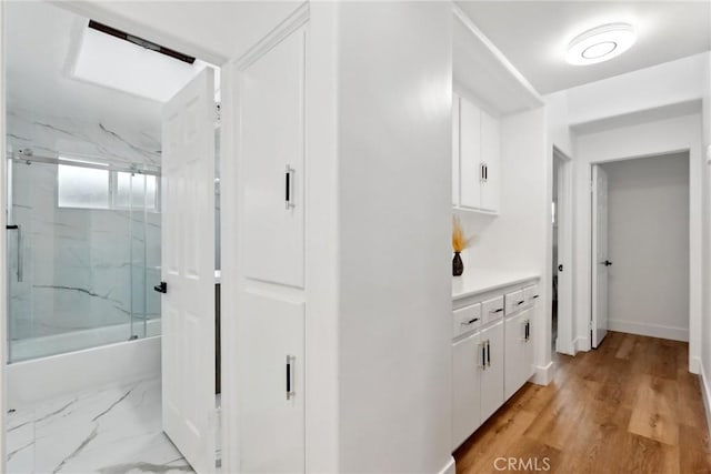 interior space featuring vanity and bath / shower combo with glass door