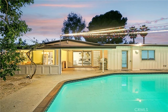 pool at dusk with a patio