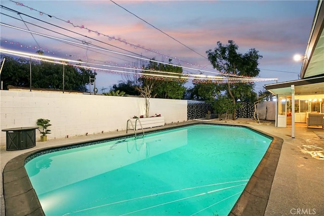 pool at dusk featuring a patio