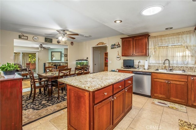 kitchen featuring light tile patterned floors, sink, dishwasher, light stone counters, and a center island