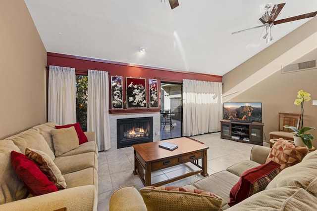 tiled living room featuring vaulted ceiling, ceiling fan, and a healthy amount of sunlight