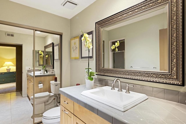 bathroom featuring toilet, a shower with door, and vanity