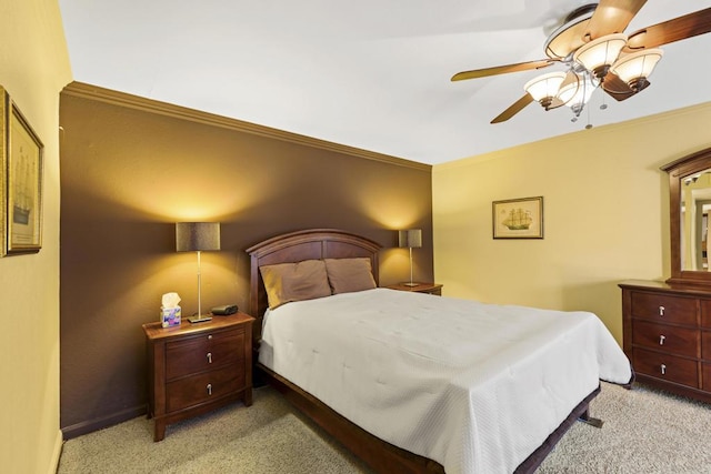 carpeted bedroom with ceiling fan and ornamental molding