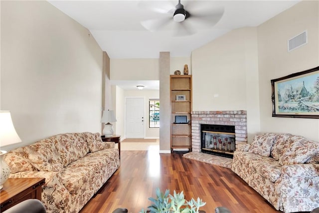 living room with ceiling fan, wood-type flooring, vaulted ceiling, and a fireplace