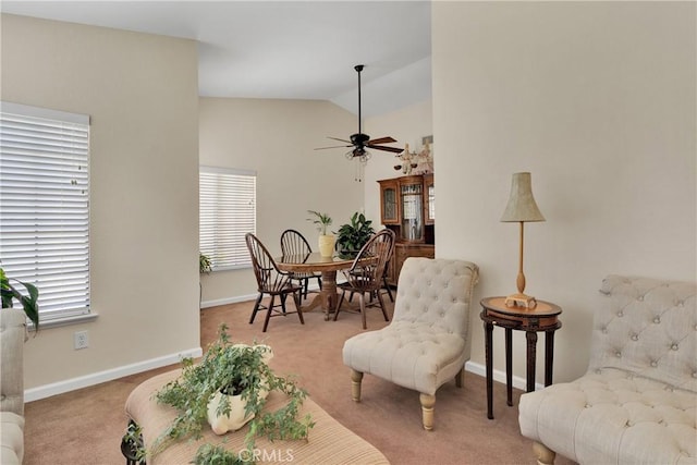 living area with ceiling fan, light colored carpet, and vaulted ceiling