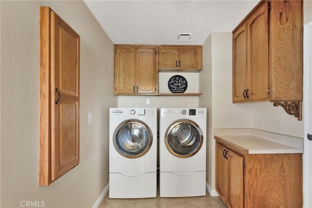 washroom featuring cabinets and washing machine and clothes dryer