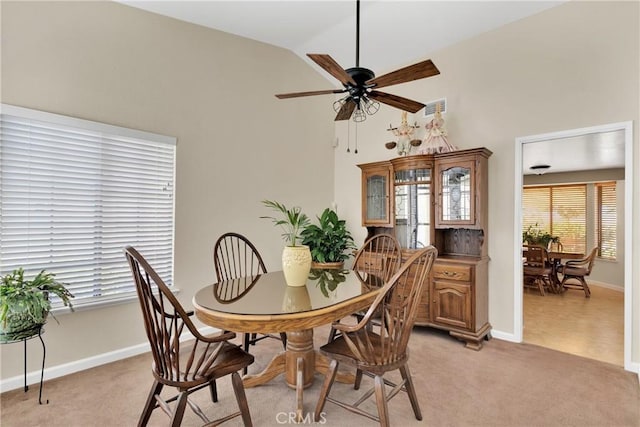 dining area with light carpet, ceiling fan, and lofted ceiling