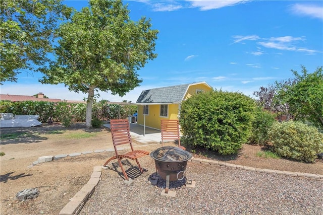 view of front of home with an outdoor fire pit and an outdoor structure