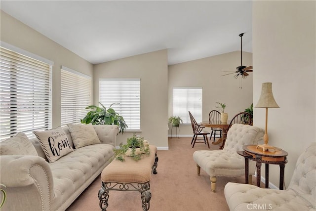 living room with ceiling fan, light colored carpet, and vaulted ceiling