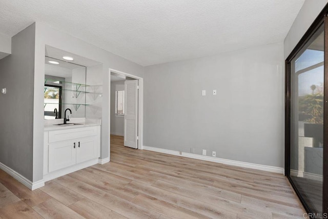 interior space with light hardwood / wood-style floors, sink, and a textured ceiling