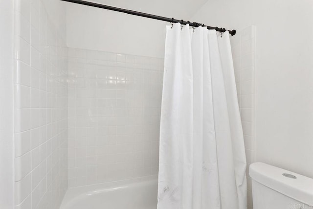 bathroom featuring toilet and shower / tub combo