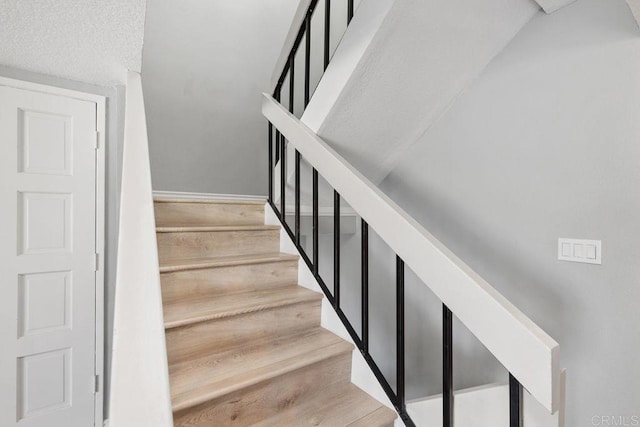 stairs with hardwood / wood-style flooring and a textured ceiling