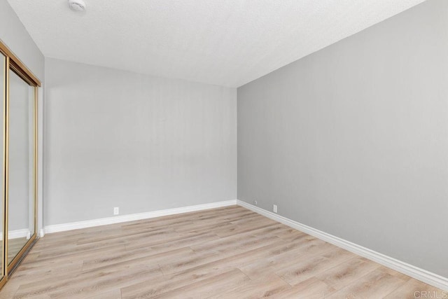 unfurnished bedroom with a closet and light hardwood / wood-style flooring