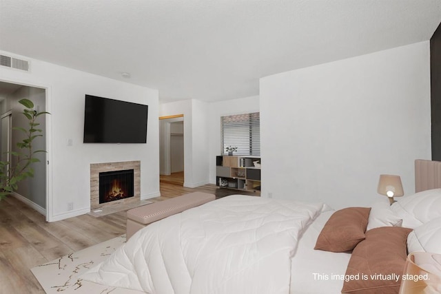 bedroom featuring a closet, light hardwood / wood-style flooring, and a walk in closet