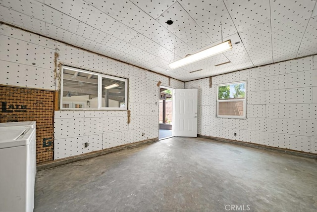 empty room with independent washer and dryer and concrete flooring