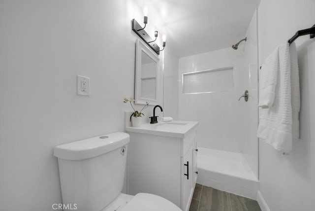 bathroom with toilet, a shower, and vanity