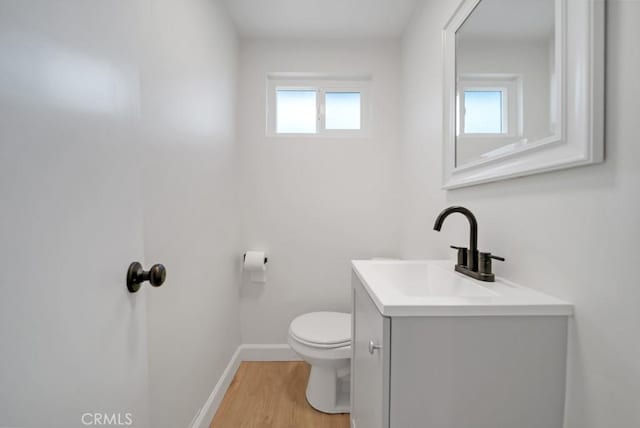 bathroom with toilet, wood-type flooring, and vanity