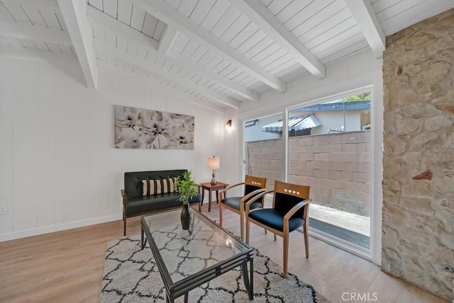 living area with light hardwood / wood-style floors and beam ceiling