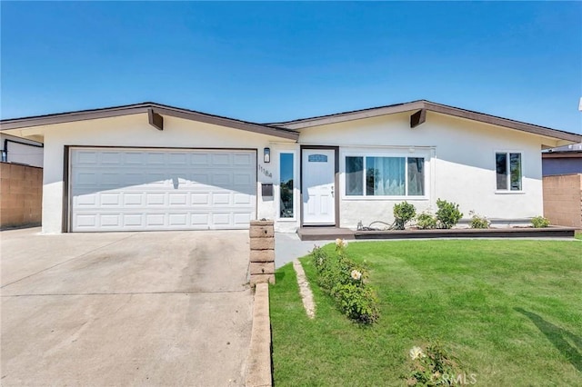 ranch-style house featuring a front lawn and a garage