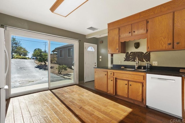 kitchen with dark hardwood / wood-style flooring, sink, and white appliances