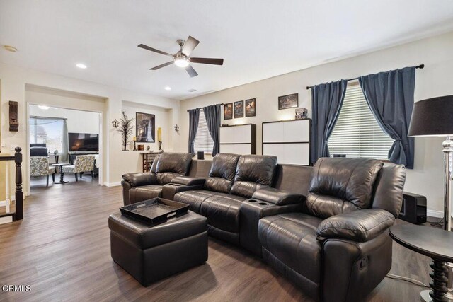 living room with dark wood-type flooring and ceiling fan