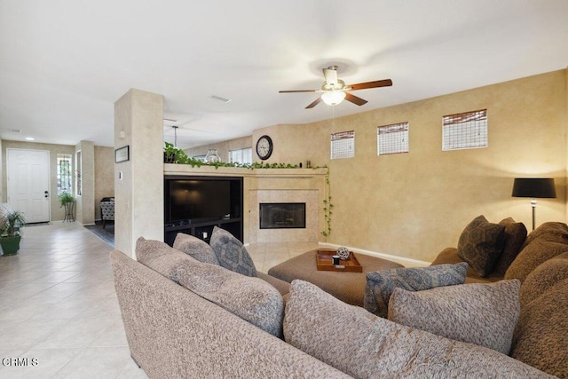 living room with ceiling fan and a tile fireplace