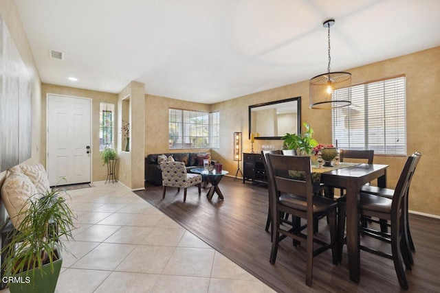 dining area with light tile patterned floors and a notable chandelier