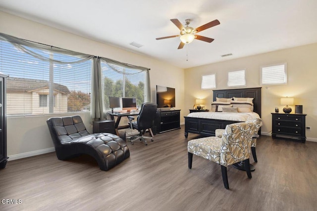 bedroom featuring ceiling fan, dark hardwood / wood-style flooring, and multiple windows