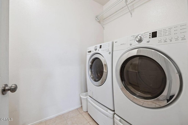 laundry room with separate washer and dryer and light tile patterned flooring