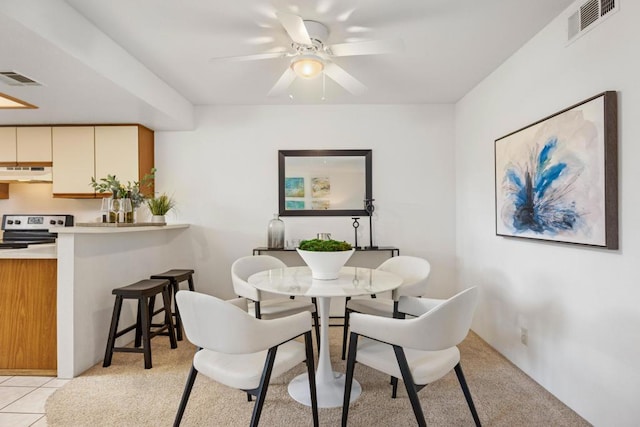 tiled dining space featuring ceiling fan