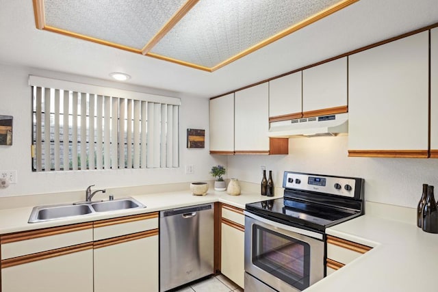 kitchen with light tile patterned flooring, stainless steel appliances, white cabinets, and sink