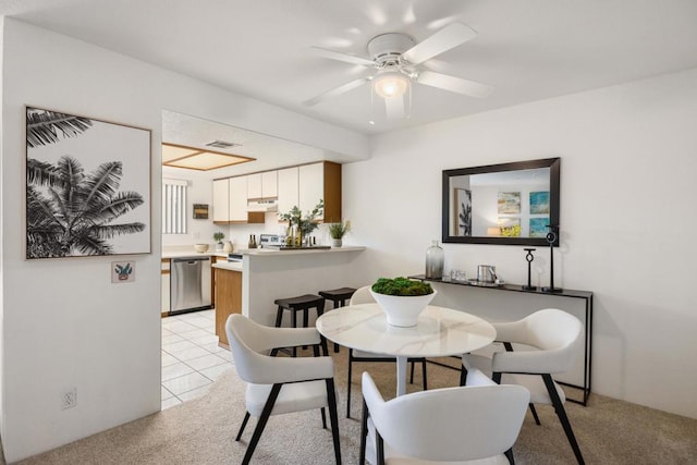 carpeted dining area with ceiling fan