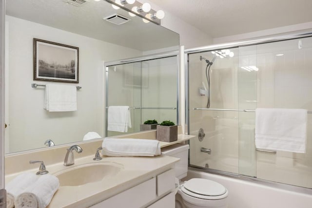 full bathroom featuring toilet, combined bath / shower with glass door, and vanity