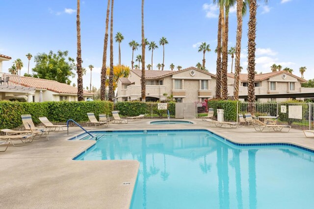 view of swimming pool featuring a hot tub and a patio