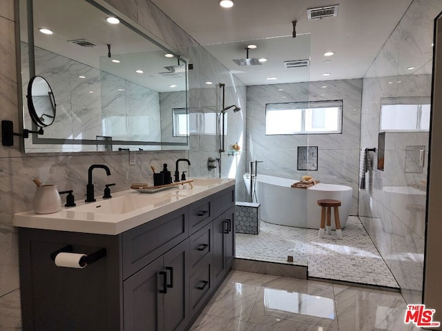 bathroom with a tub, vanity, and tile walls