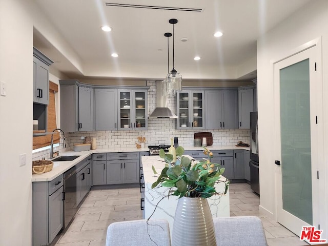 kitchen with decorative light fixtures, wall chimney range hood, gray cabinets, black appliances, and sink