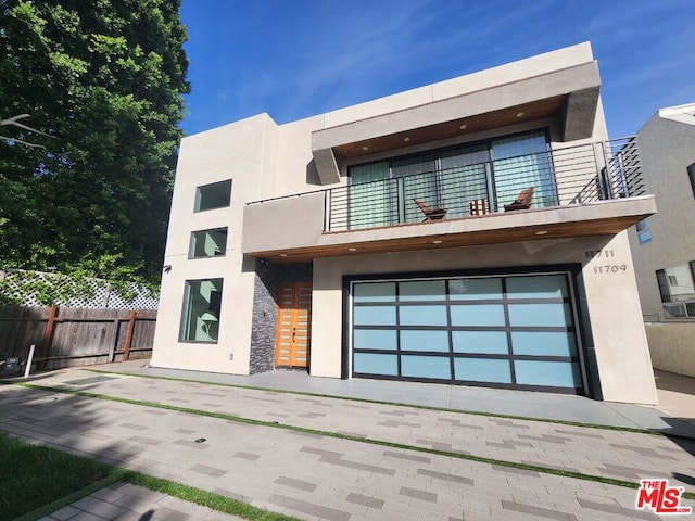 contemporary home featuring a balcony and a garage