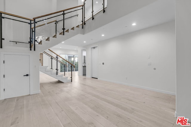 entryway featuring a high ceiling and light hardwood / wood-style flooring