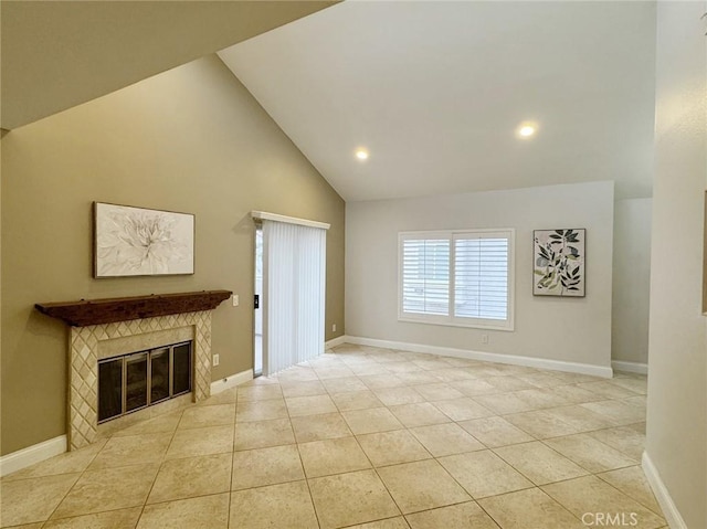 unfurnished living room with high vaulted ceiling, a tiled fireplace, and light tile patterned flooring