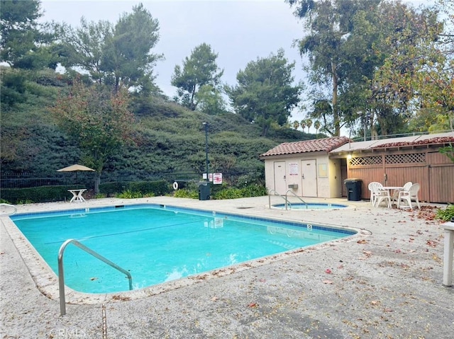 view of swimming pool with a hot tub and a patio