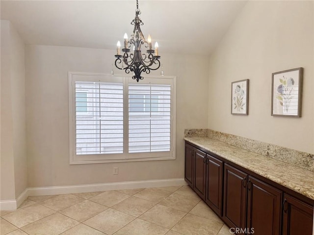 unfurnished dining area with vaulted ceiling, light tile patterned floors, and a chandelier