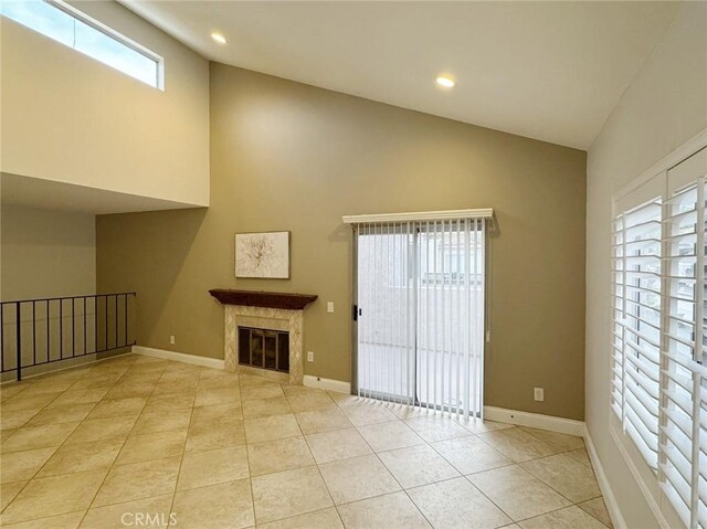 unfurnished living room with a high end fireplace and light tile patterned floors