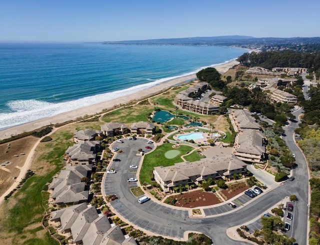 drone / aerial view with a water view and a beach view