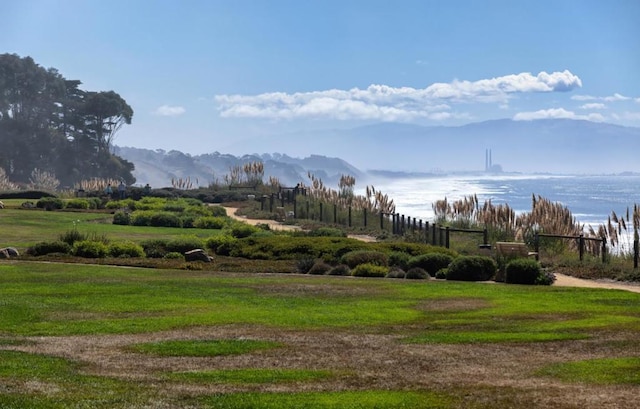 surrounding community with a rural view, a mountain view, and a yard