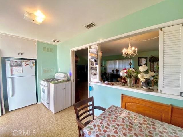 kitchen with white appliances, a notable chandelier, and hanging light fixtures