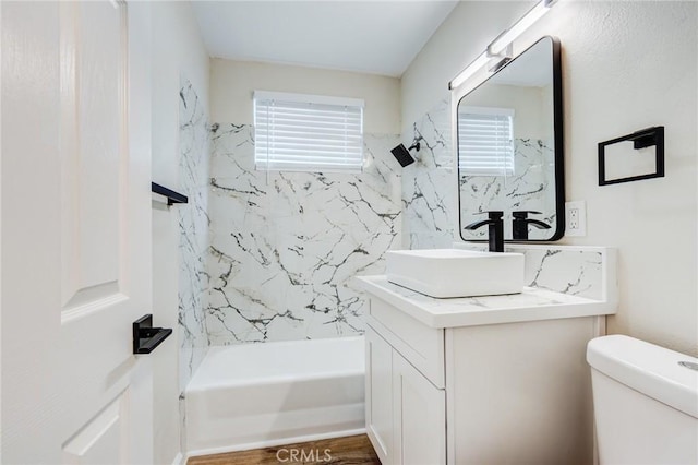 bathroom featuring toilet, vanity, and shower / bathing tub combination