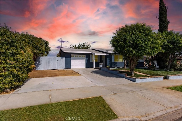 single story home with driveway, roof mounted solar panels, fence, a front yard, and a garage