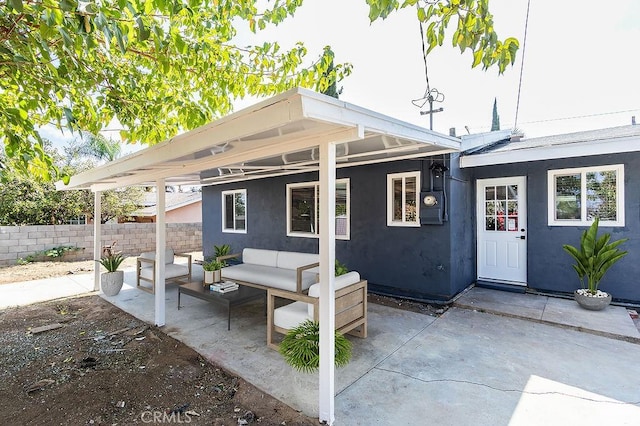 back of property featuring an outdoor living space and a patio area